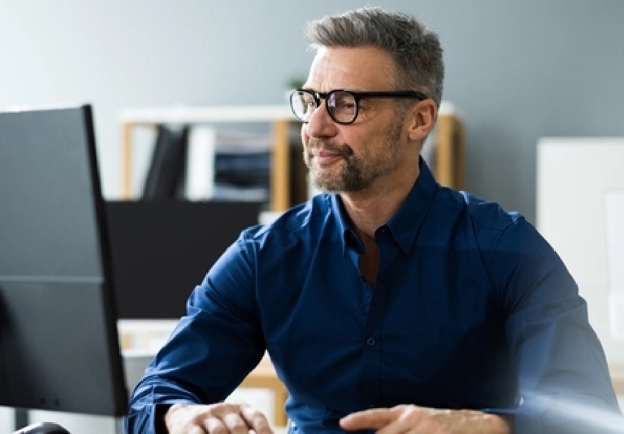 Man sitting at desk looking at computer monitor