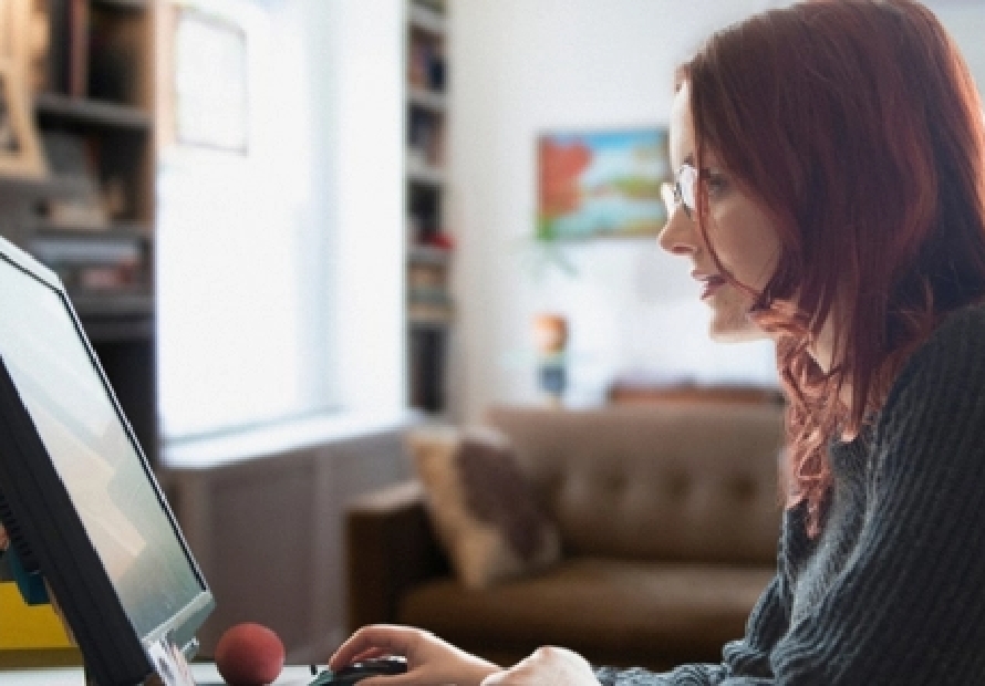 Woman sitting at desk typing on computer