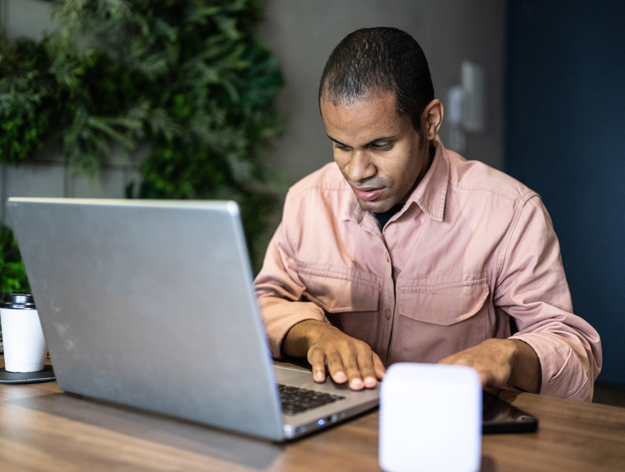 Blind man at laptop using assistive technology
