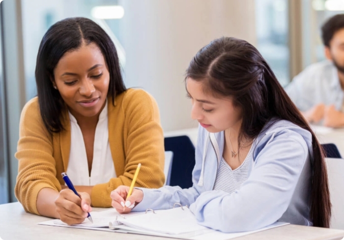 Instructor working with a student at a desk.
